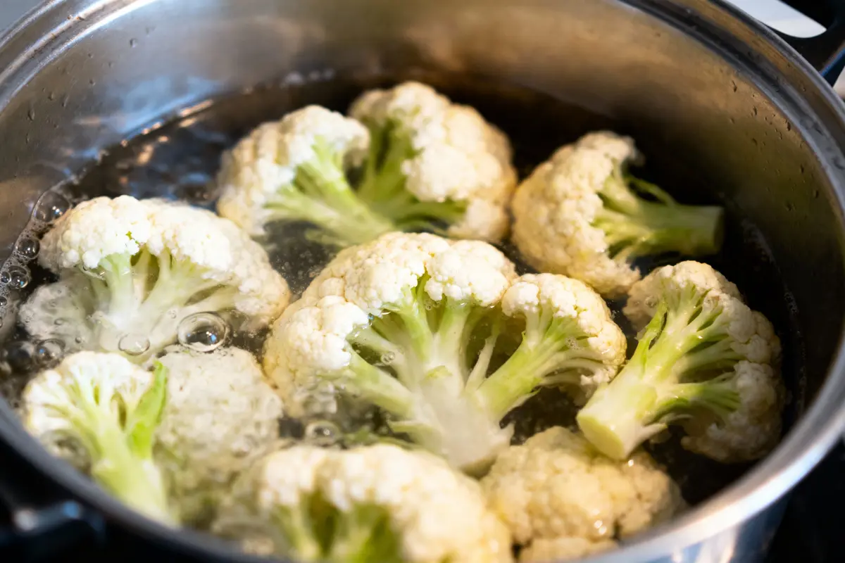 Choux-fleurs bouillants dans une casserole avec de l'eau bouillante sur une cuisinière.