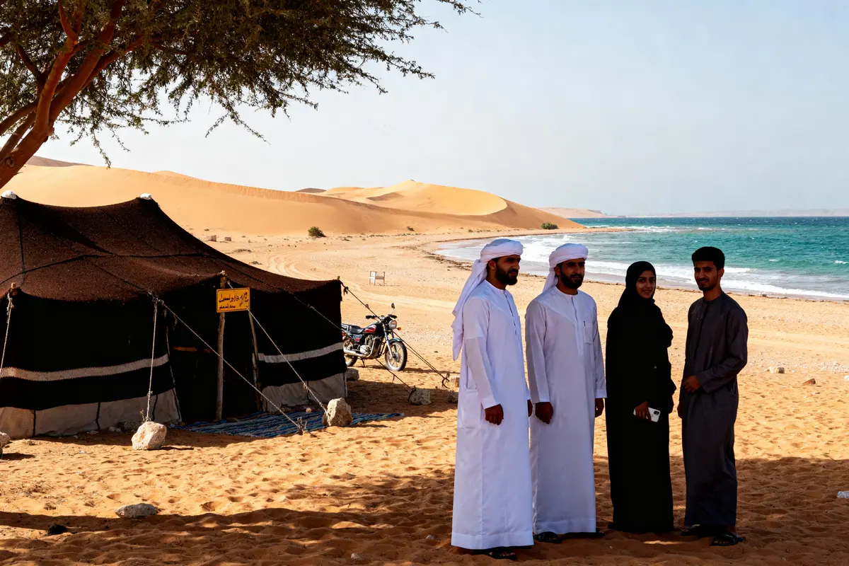 Groupe près d'une tente bédouine sur une plage d'un pays commençant par la lettre O