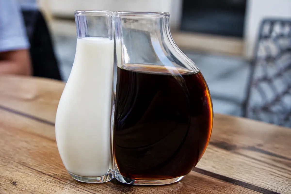 pexels-michal-pech-213601-757318 (1) Deux carafes imbriquées contenant lait et liqueur de Sheridan's sur table en bois.
